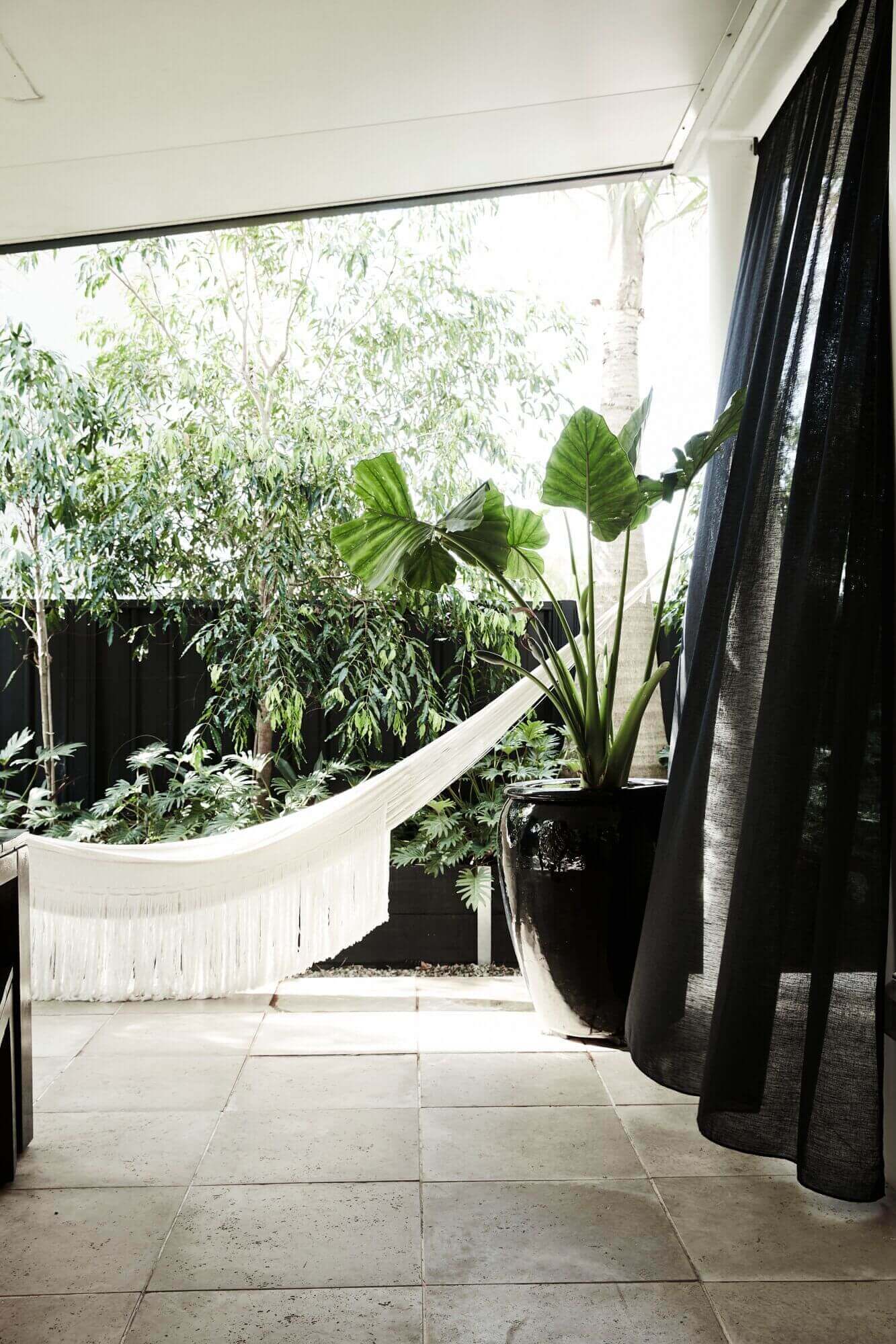 Cream fringed hammock in the private courtyard at Bower House, The Bower Byron Bay