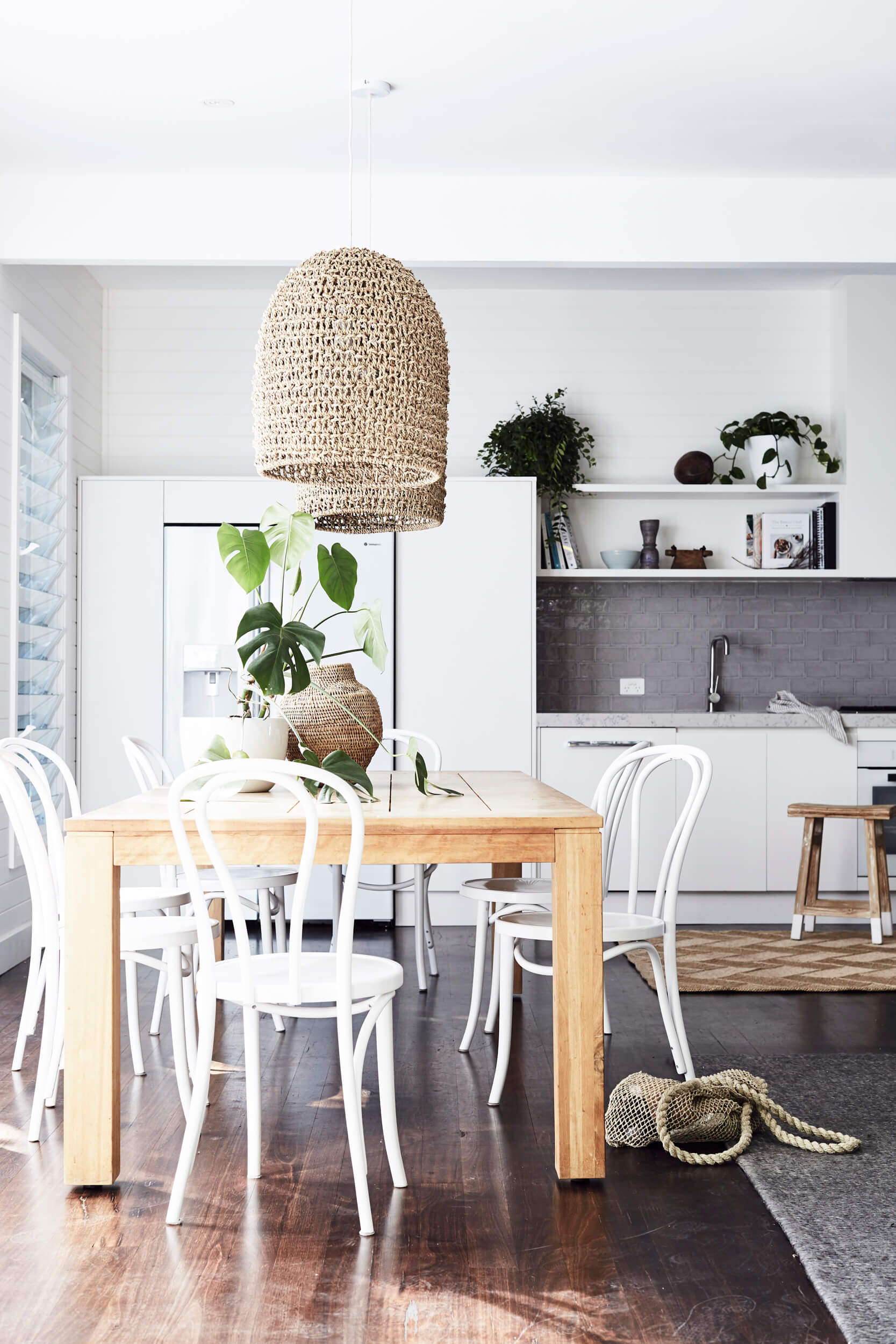 Dining table with overhanging woven pendant lights at The Cottage, The Bower Byron Bay