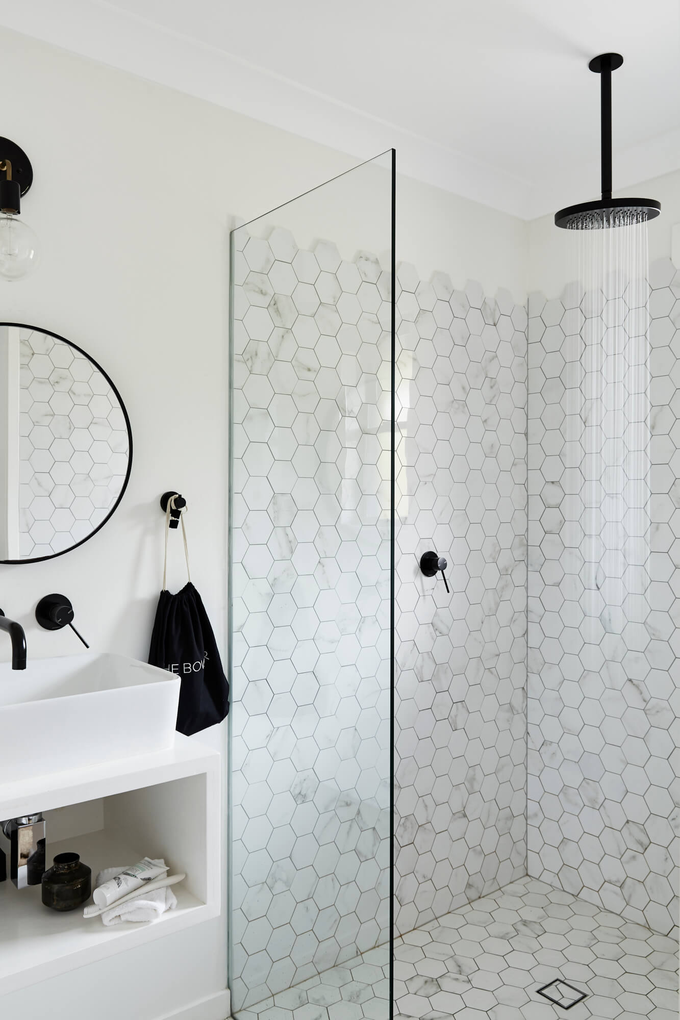 Ensuite at Bower House, The Bower Byron Bay featuring hexagonal tiles in the shower and a round mirror above vanity