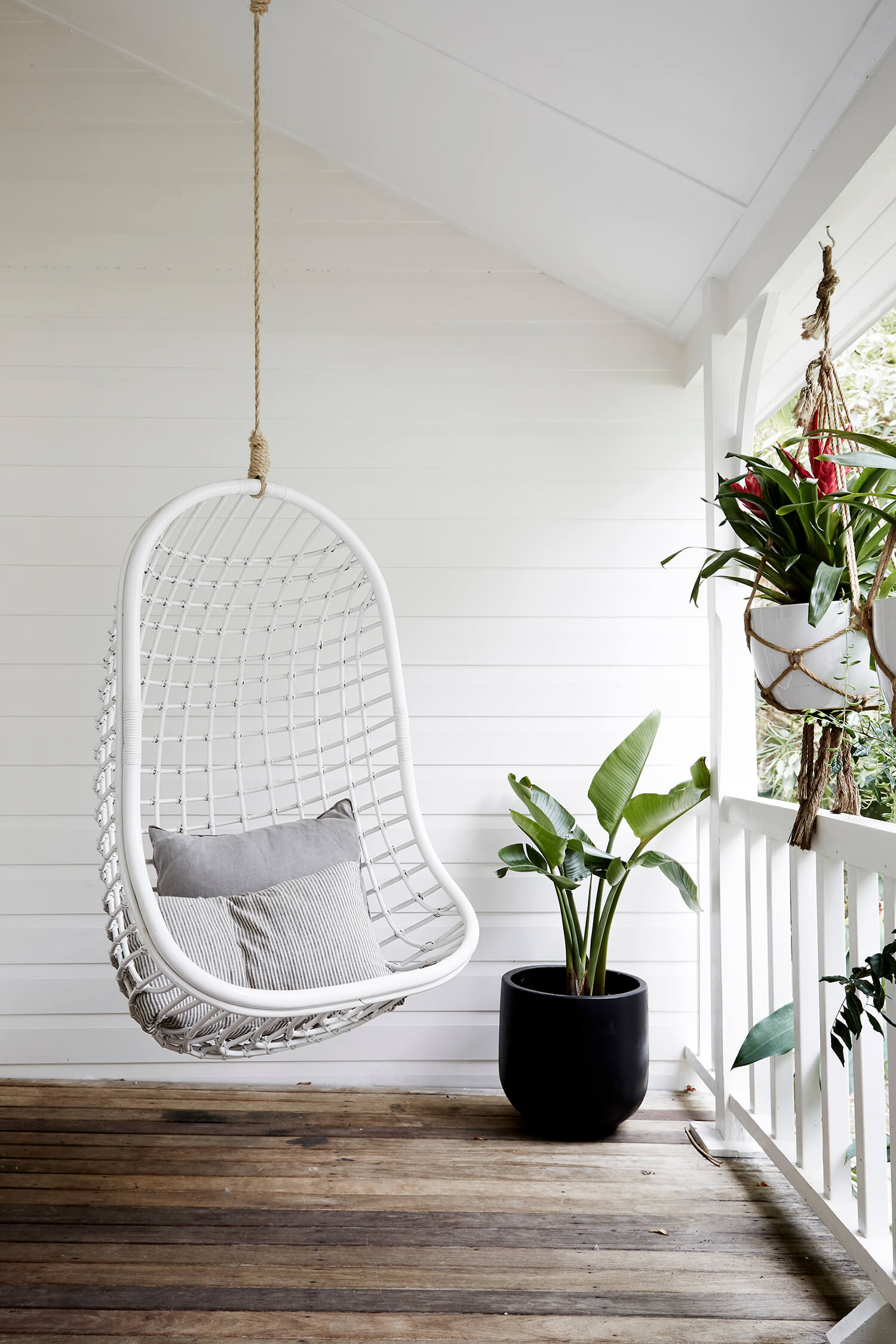 White cane hanging chair on the verandah at The Cottage, The Bower Byron Bay