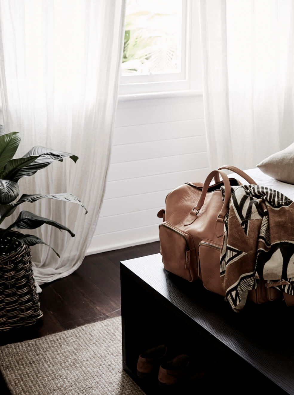 Leather overnight bag at the end of the bed at The Cottage, The Bower Byron Bay