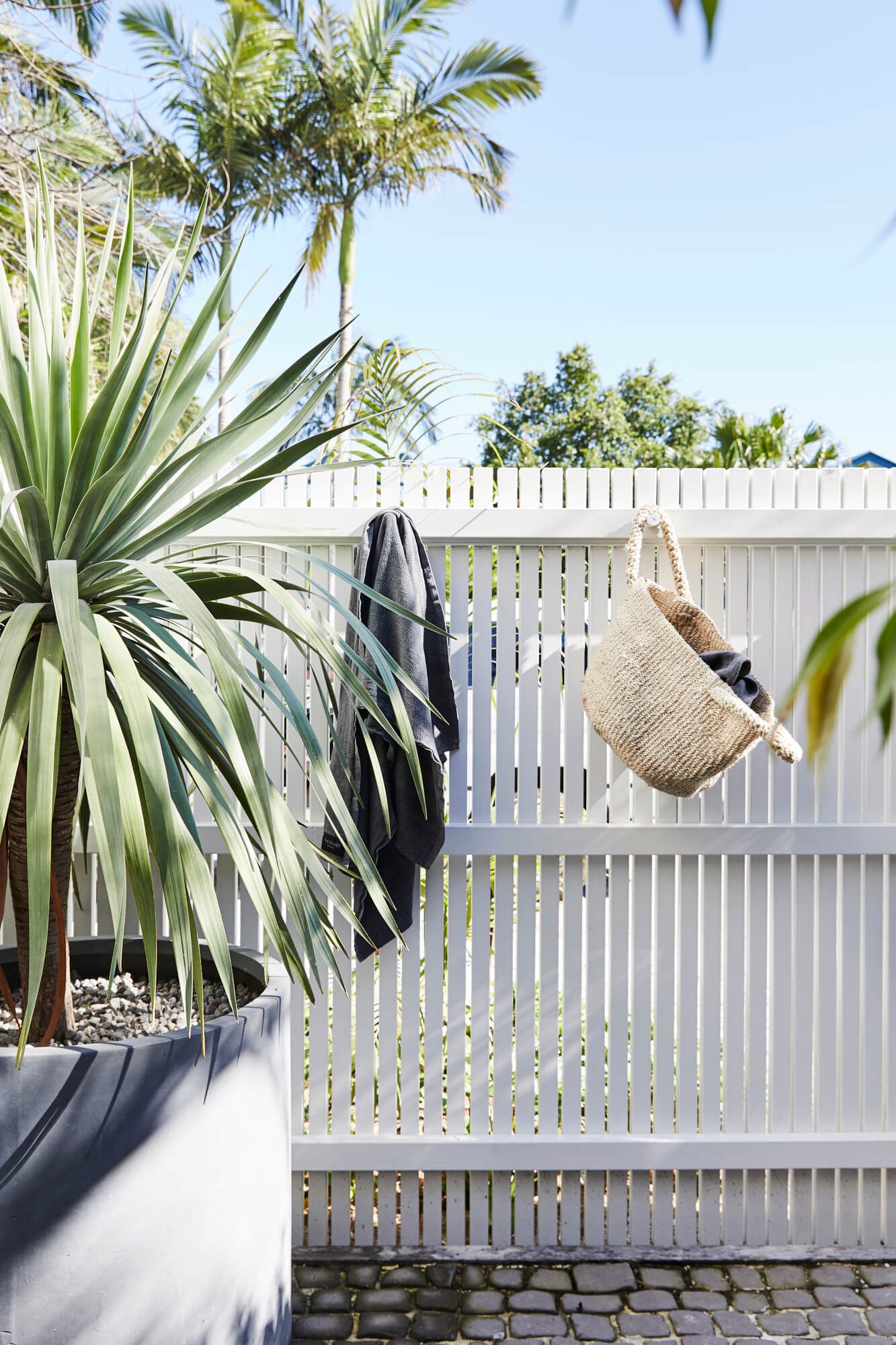 Woven beach bag and towel hanging on fence at the Bower Barn, The Bower Byron Bay hotel