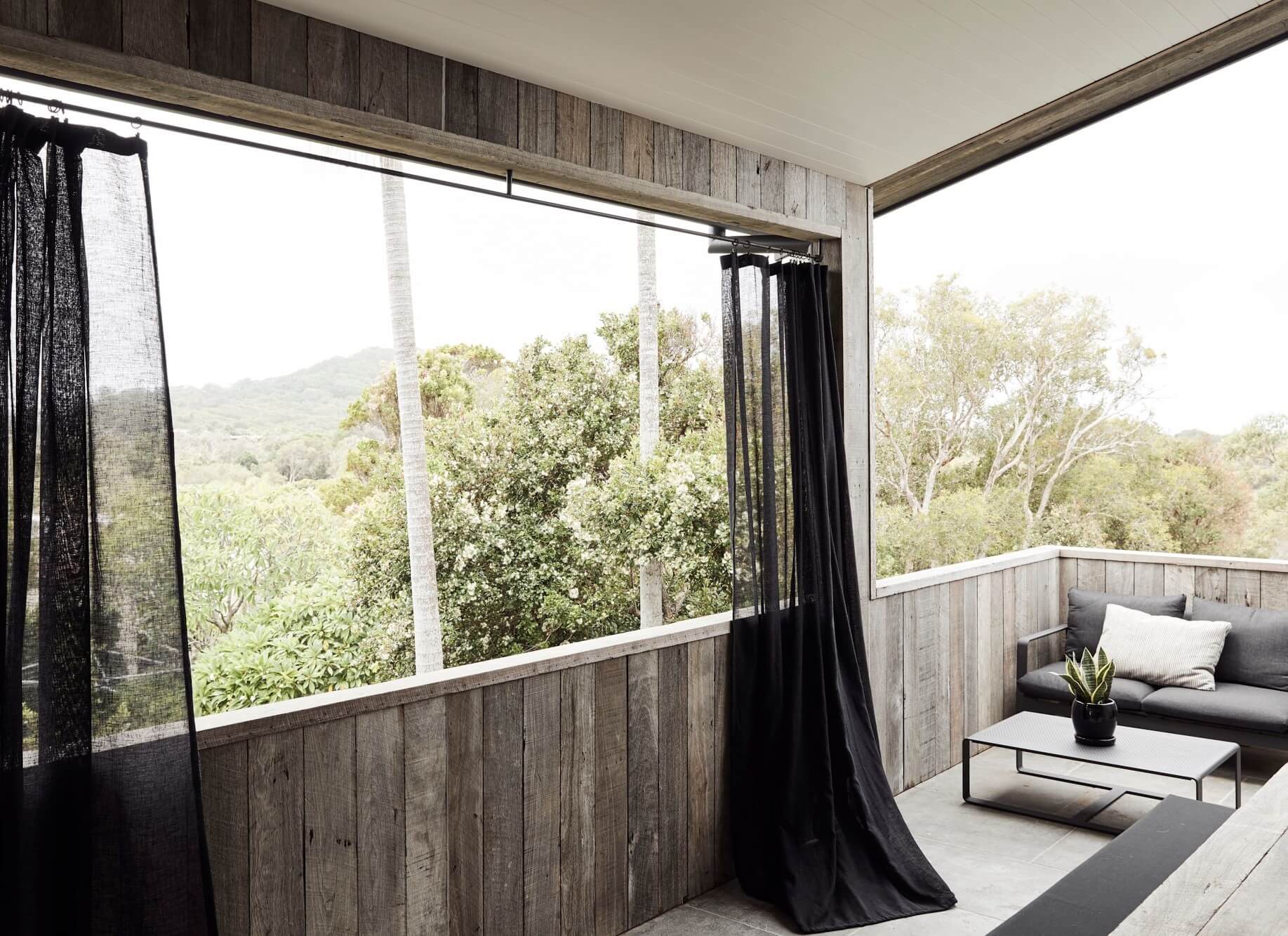 Outdoor lounge area at The Lodge, Byron Beach Abodes overlooking the Byron Bay bushland