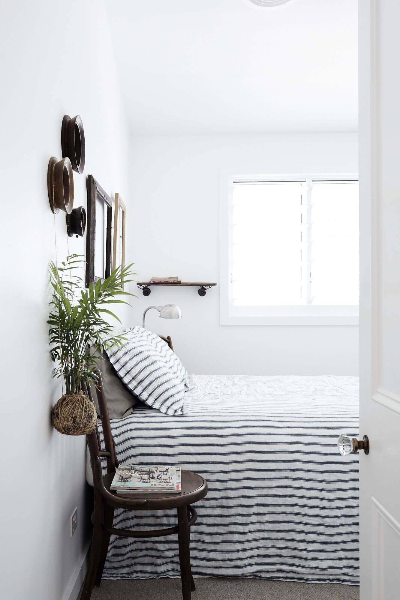 Stylish bedroom at Magnolia House, Byron Beach Abodes with classic striped bed linen and curated vintage wall art
