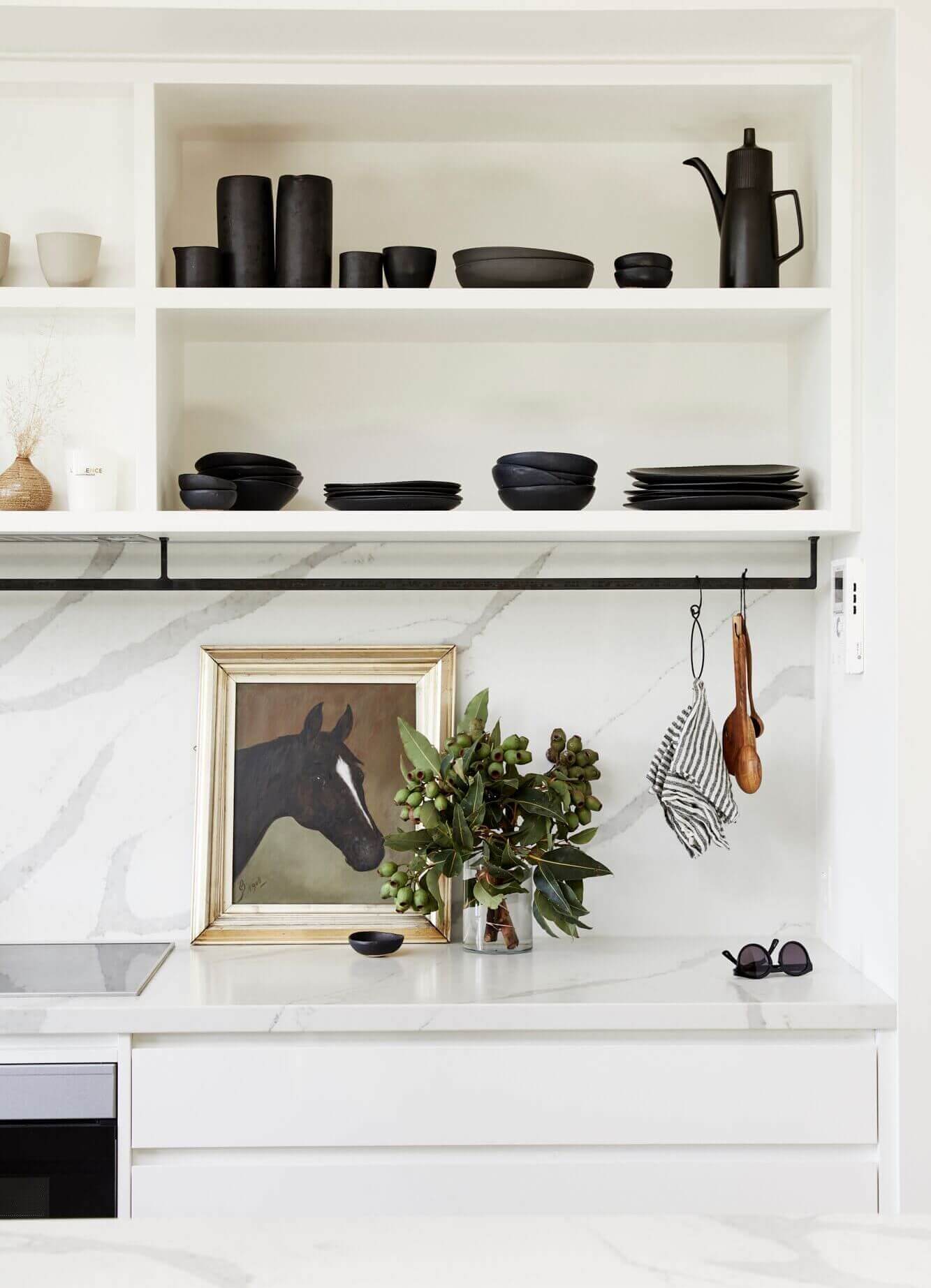 Open shelving i the kitchen at The Lodge, Byron Beach Abodes with handmade ceramics, vintage artwork and greenery