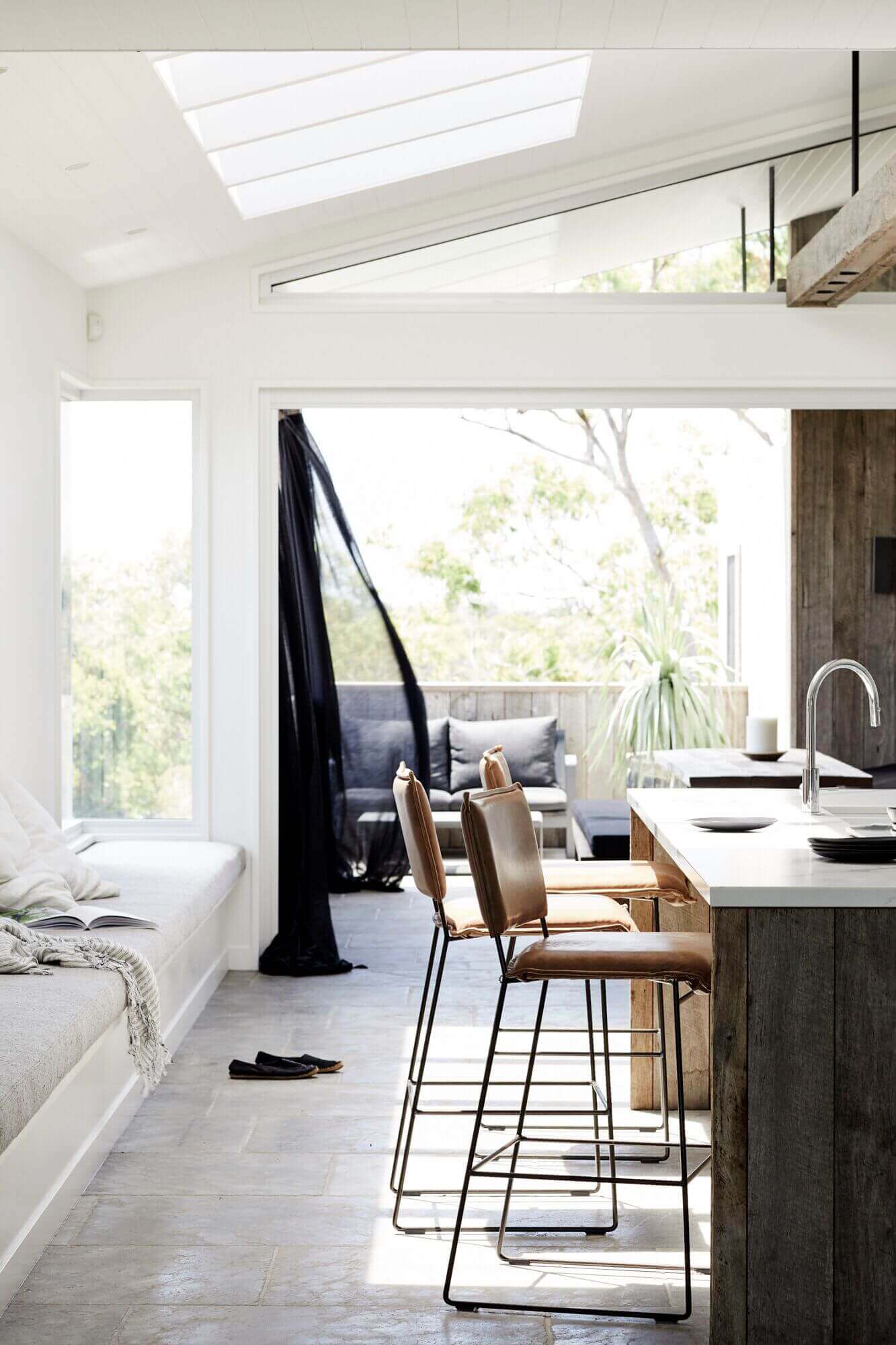 Open plan kitchen, banquette seating, and outdoor sitting area at The Lodge, Byron Beach Abodes
